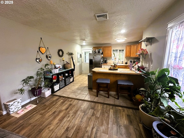 dining space with a textured ceiling and light hardwood / wood-style flooring