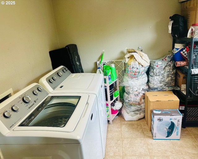 laundry area with washer and clothes dryer and light tile patterned flooring