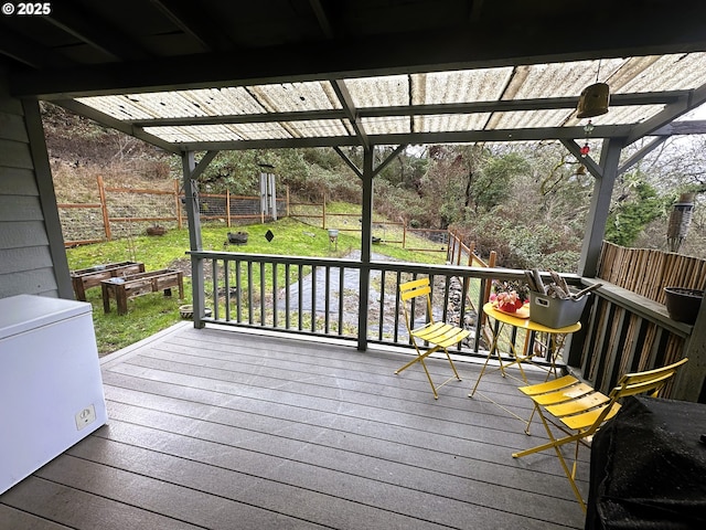 wooden terrace with a pergola and a lawn