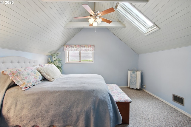 bedroom featuring visible vents, lofted ceiling with skylight, baseboards, carpet flooring, and ceiling fan