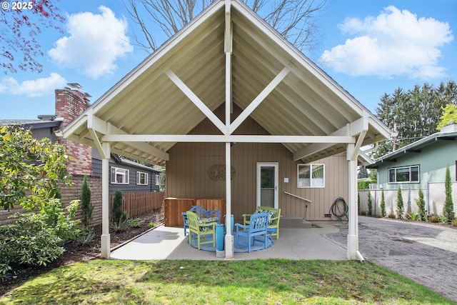 rear view of property featuring fence and a patio area