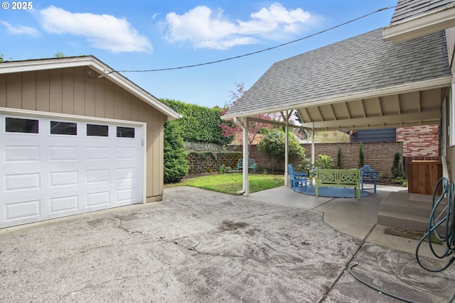 detached garage with driveway and fence