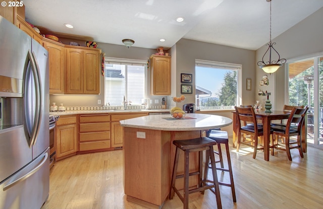 kitchen featuring stainless steel fridge with ice dispenser, plenty of natural light, light wood-style floors, recessed lighting, and lofted ceiling