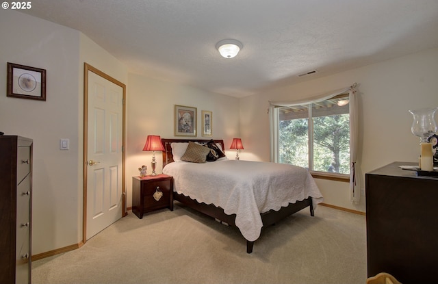 bedroom with light colored carpet and baseboards