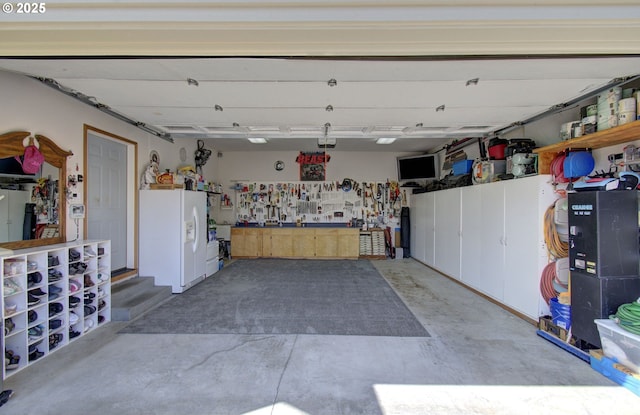 garage with white refrigerator with ice dispenser and a workshop area