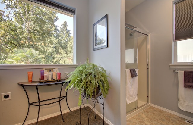 bathroom featuring a stall shower and baseboards