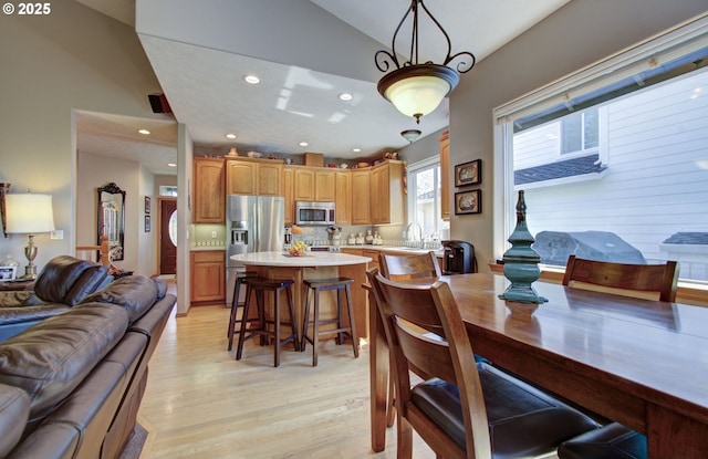 dining room with lofted ceiling, light wood-type flooring, and recessed lighting