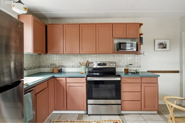 kitchen featuring decorative backsplash, dark countertops, appliances with stainless steel finishes, and light tile patterned flooring