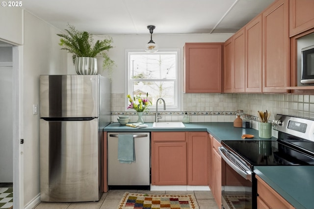 kitchen featuring a sink, stainless steel appliances, tasteful backsplash, and pendant lighting