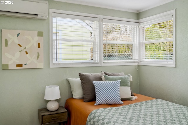 bedroom with a textured wall, crown molding, and a wall unit AC