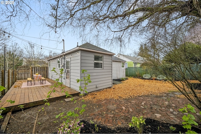 view of side of home featuring a wooden deck and a fenced backyard