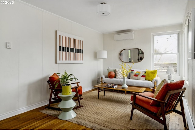 living area featuring baseboards, wood finished floors, ornamental molding, and a wall unit AC