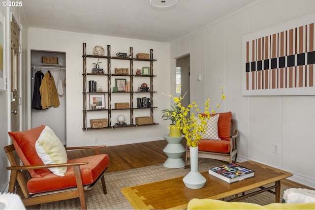 sitting room with a decorative wall and wood finished floors