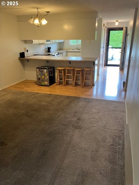 3404 19th Ave Unit 103, Forest Grove, OR 97116 - kitchen featuring carpet, a peninsula, and a kitchen bar