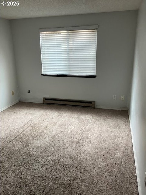 3404 19th Ave Unit 103, Forest Grove, OR 97116 - carpeted spare room with baseboard heating and a textured ceiling