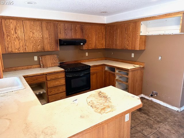 kitchen featuring sink, black range with electric cooktop, range hood, kitchen peninsula, and a textured ceiling