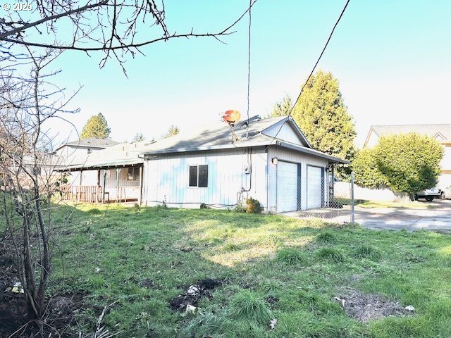 back of property with a lawn and a garage