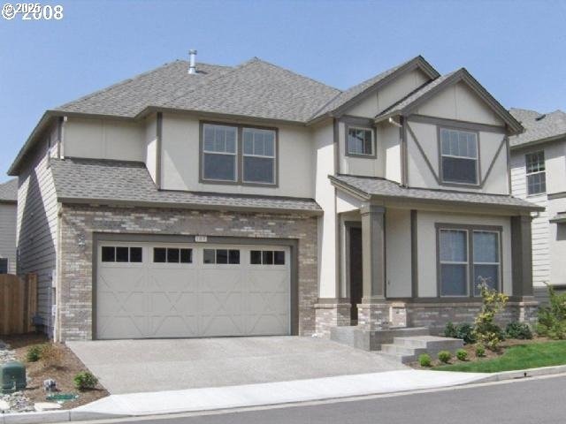 197 NE 61st Ter, Hillsboro, OR 97124 - view of front of property featuring driveway, fence, a garage, brick siding, and stucco siding