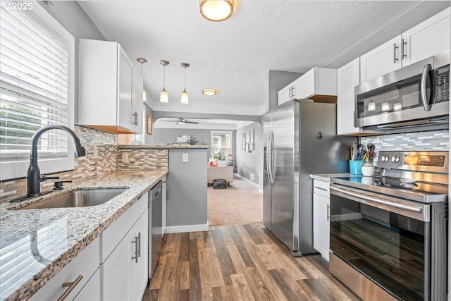 6955 N Concord Ave, Portland, OR 97217 - kitchen with appliances with stainless steel finishes, a sink, ceiling fan, dark wood finished floors, and tasteful backsplash