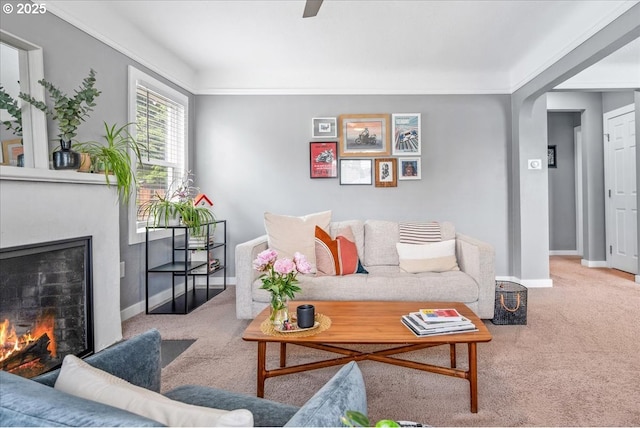 6955 N Concord Ave, Portland, OR 97217 - carpeted living area featuring a warm lit fireplace, baseboards, and arched walkways