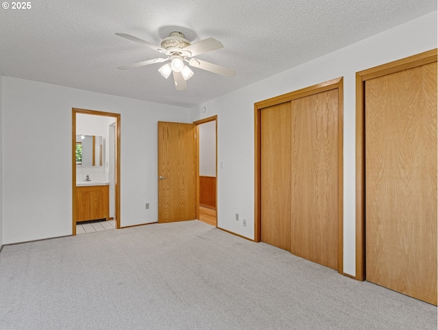 3123 SE 129th Ave, Portland, OR 97236 - unfurnished bedroom with multiple closets, light colored carpet, ensuite bath, a textured ceiling, and ceiling fan