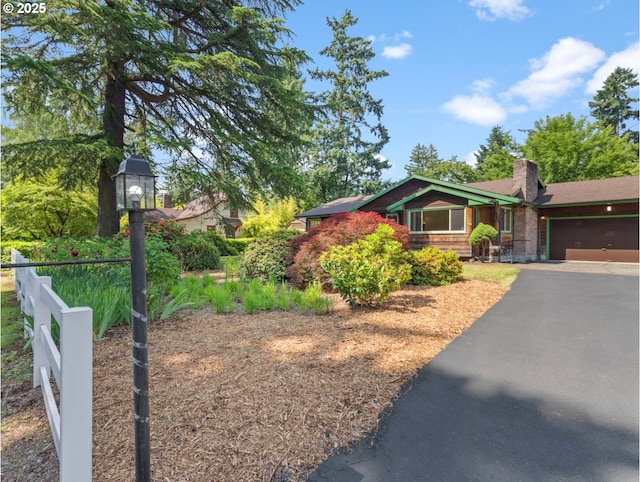 3123 SE 129th Ave, Portland, OR 97236 - view of front of house with an attached garage, asphalt driveway, and a chimney