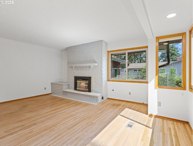 3123 SE 129th Ave, Portland, OR 97236 - unfurnished living room featuring a fireplace, wood finished floors, and a textured ceiling