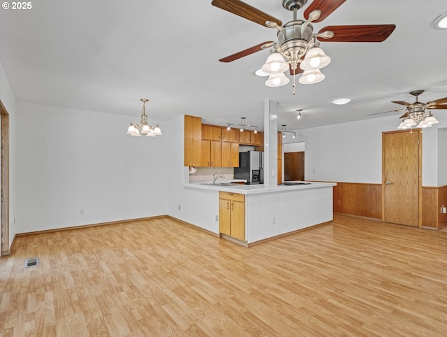 3123 SE 129th Ave, Portland, OR 97236 - kitchen featuring stainless steel refrigerator with ice dispenser, a peninsula, a ceiling fan, light wood-style floors, and a wainscoted wall