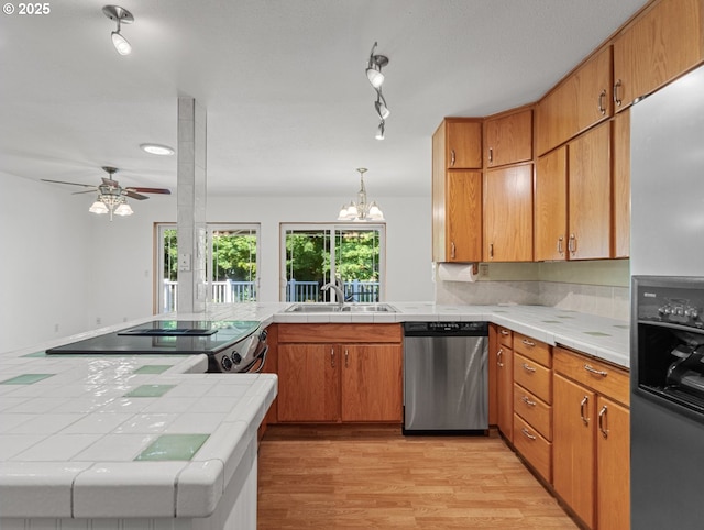 3123 SE 129th Ave, Portland, OR 97236 - kitchen with appliances with stainless steel finishes, tile countertops, ceiling fan, light wood-style flooring, and a chandelier
