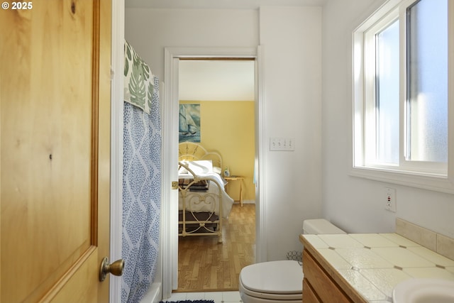 bathroom featuring vanity, hardwood / wood-style floors, and toilet