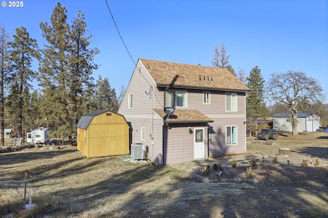 back of property with central AC and a shed