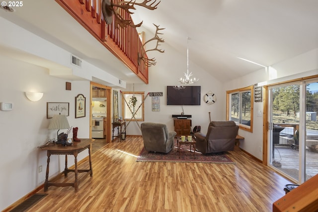 living room featuring high vaulted ceiling, a notable chandelier, and light wood-type flooring