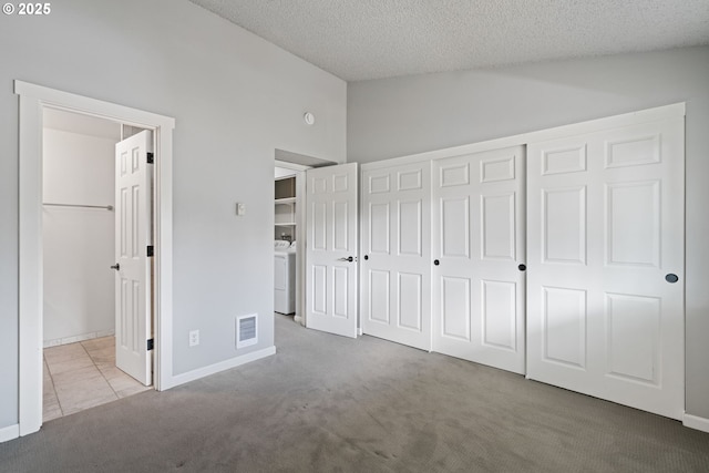 13216 NE Salmon Creek Ave Unit E8, Vancouver, WA 98686 - unfurnished bedroom featuring vaulted ceiling, carpet floors, washer / dryer, a closet, and a textured ceiling