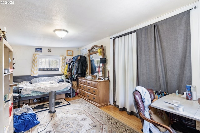 bedroom with wood finished floors and a textured ceiling