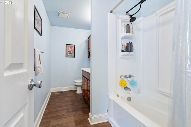 full bathroom with wood finished floors, vanity, baseboards, shower / tub combo, and toilet