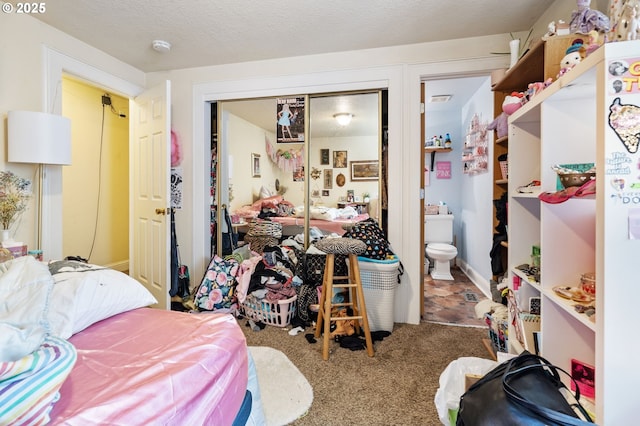 carpeted bedroom featuring a closet and ensuite bathroom