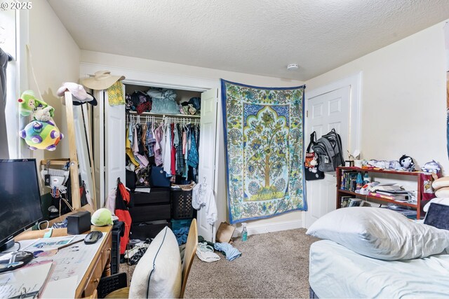carpeted bedroom with a closet and a textured ceiling