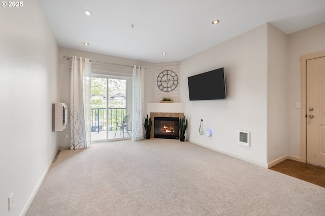 10664 NE Holly St # 206, Hillsboro, OR 97006 - unfurnished living room featuring carpet flooring, heating unit, a glass covered fireplace, and recessed lighting