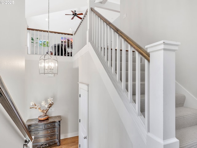 10305 Pine Ridge Dr, Manzanita, OR 97130 - staircase with a high ceiling, a chandelier, a ceiling fan, and wood finished floors