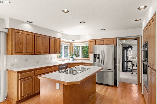 15150 SE Lostine Dr, Clackamas, OR 97015 - kitchen featuring appliances with stainless steel finishes, tile countertops, recessed lighting, a center island, and backsplash