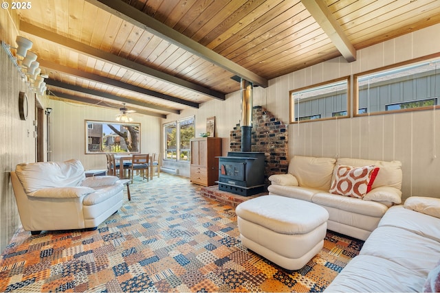 8890 Ocean Crest Ln, Manzanita, OR 97130 - living room with a wood stove, wood walls, wooden ceiling with exposed beams, and carpet floors