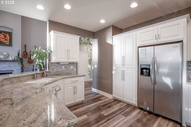 195 Daniel Dr, Eugene, OR 97404 - kitchen featuring stainless steel refrigerator with ice dispenser, decorative backsplash, wood finished floors, light stone countertops, and white cabinets