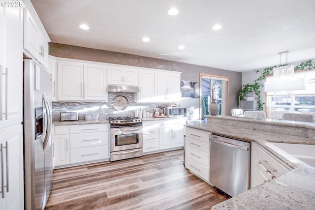 195 Daniel Dr, Eugene, OR 97404 - kitchen with stainless steel appliances, white cabinets, light wood-style flooring, decorative backsplash, and recessed lighting