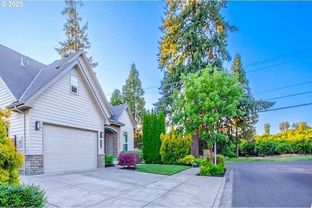 195 Daniel Dr, Eugene, OR 97404 - view of front of house with concrete driveway, stone siding, and an attached garage