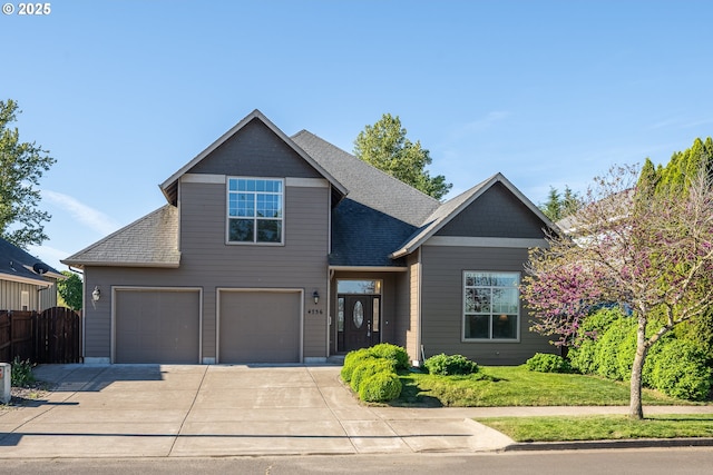 view of front of house with an attached garage, driveway, fence, and roof with shingles