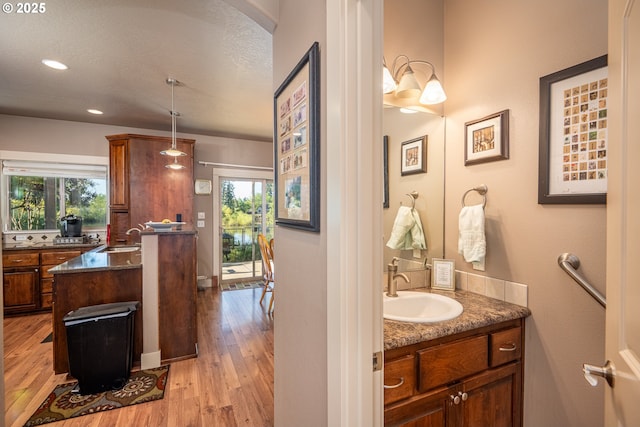 bathroom with wood finished floors, vanity, and recessed lighting