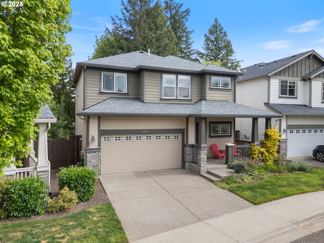 20317 SW Gracie St, Beaverton, OR 97006 - view of front of property with covered porch, driveway, a garage, a shingled roof, and stone siding