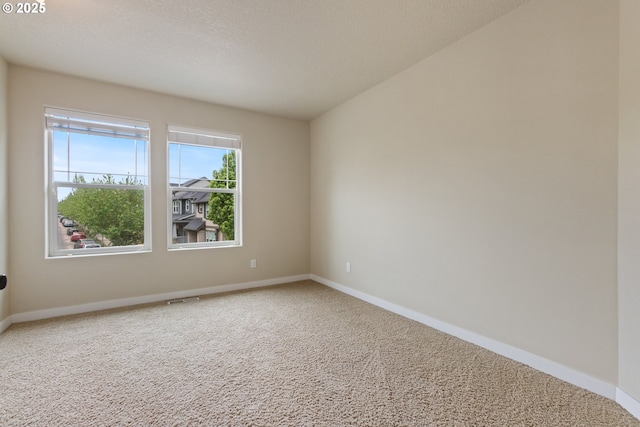 carpeted spare room with baseboards and visible vents