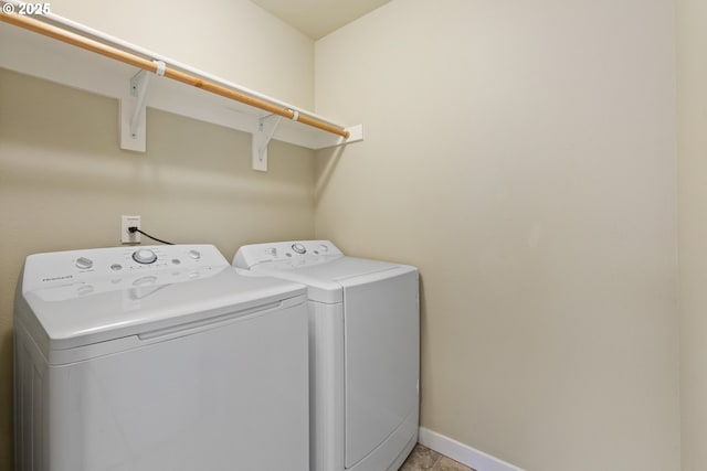 laundry room with laundry area, baseboards, light tile patterned floors, and washing machine and clothes dryer