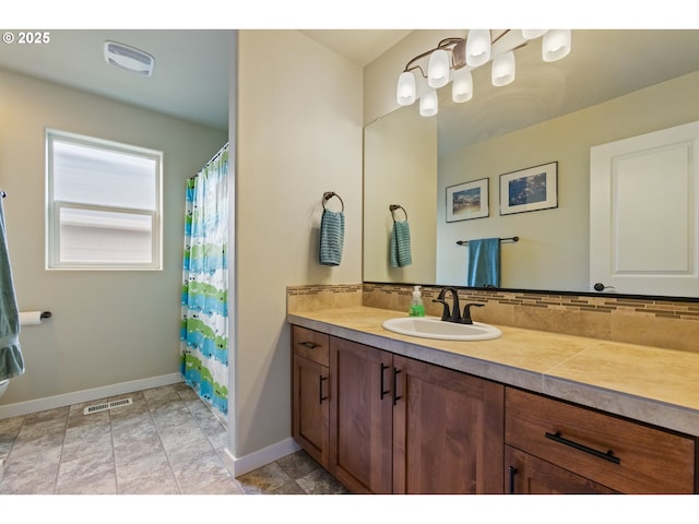 bathroom with baseboards, visible vents, decorative backsplash, and vanity